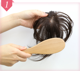 ヘアピースをブラッシングしている様子