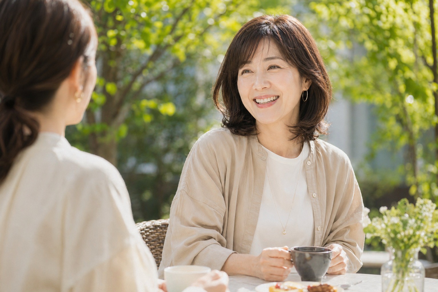ウィッグを着用した女性が屋外カフェで友人と会話しているシーン